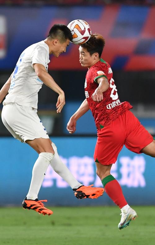     5月20日，河南队球员黄紫昌（右）与大连队球员吕鹏在中超联赛中争抢头球。新华社记者 李嘉南/摄